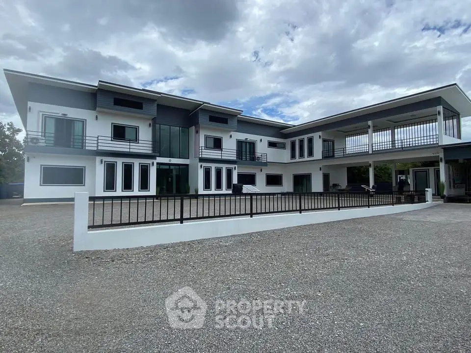Modern two-story building with spacious parking area and sleek architectural design.