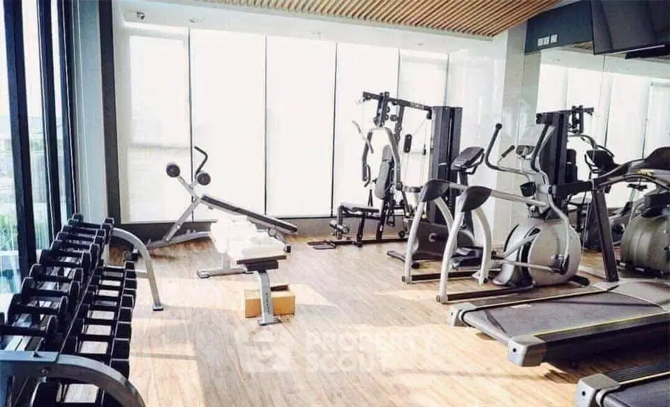 Modern gym with state-of-the-art fitness equipment and large windows for natural light.