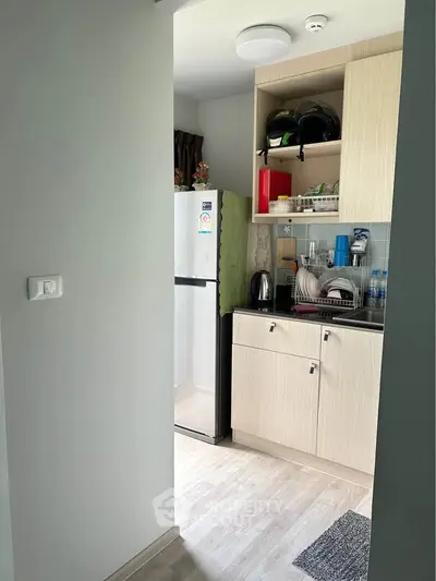 Compact kitchen with modern appliances and sleek cabinetry in a cozy apartment setting.