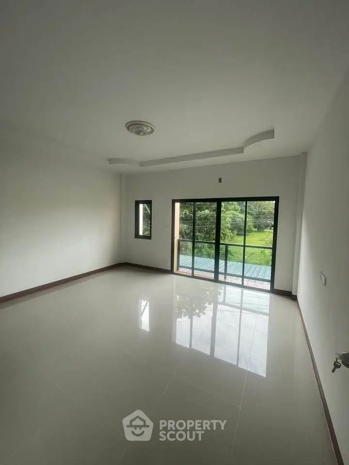 Spacious empty room with large windows and serene garden view, perfect for customization.