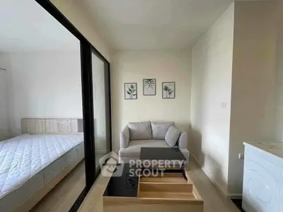 Modern apartment with cozy living area and bedroom, featuring sleek furniture and minimalist decor.