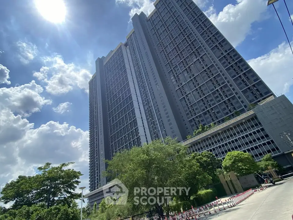 Stunning high-rise building with lush greenery and clear blue sky, perfect for urban living.