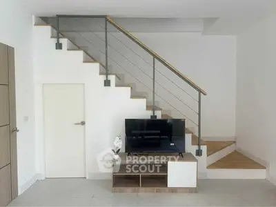 Modern minimalist living room with sleek staircase and TV unit