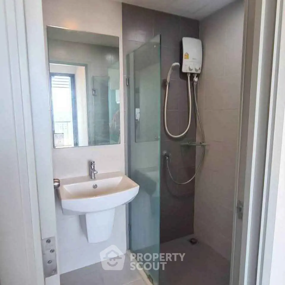 Modern bathroom with glass shower and sleek fixtures in a contemporary apartment.