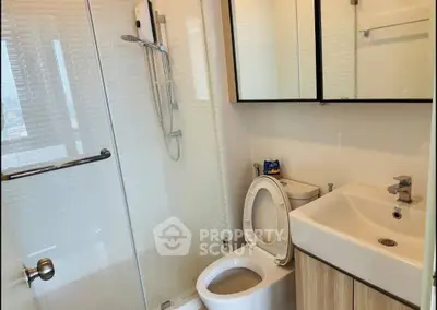 Modern bathroom with glass shower and sleek fixtures in a contemporary apartment.