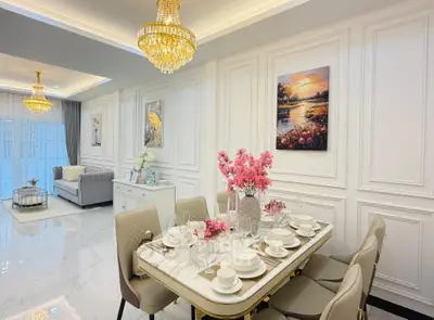 Luxurious open-plan living and dining area with elegant chandeliers and modern decor.