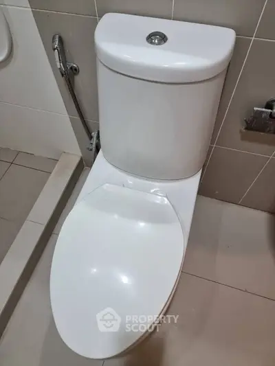 Modern bathroom with sleek white toilet and tiled walls, perfect for contemporary living spaces.