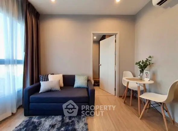 Modern living room with cozy sofa and dining area, featuring stylish decor and natural light.