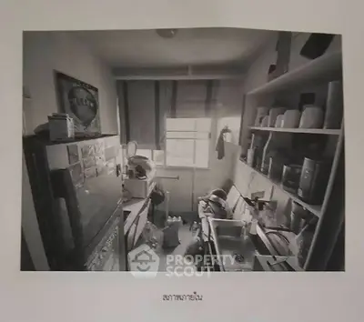 Compact kitchen with cluttered shelves and small window