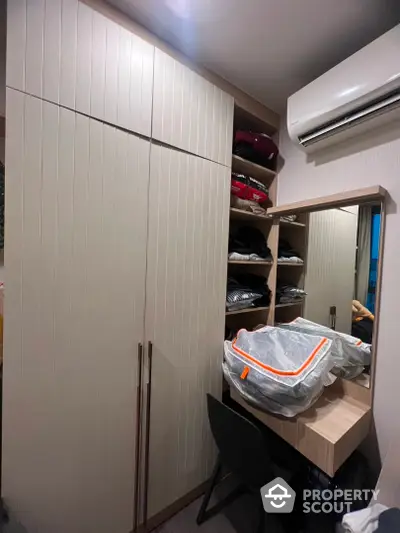 Modern bedroom with built-in wardrobe and air conditioning unit