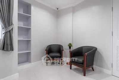 Cozy corner with elegant chairs and built-in shelves in a modern home interior.