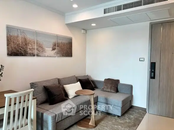 Modern living room with cozy gray sofa, stylish decor, and elegant lighting in a contemporary apartment.