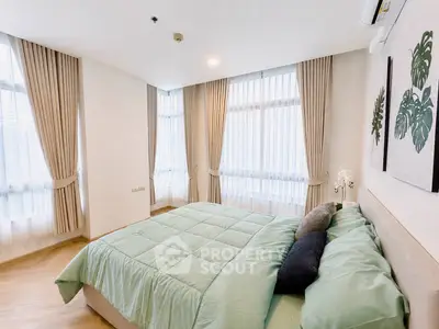 Spacious bedroom with large windows and elegant curtains in modern apartment