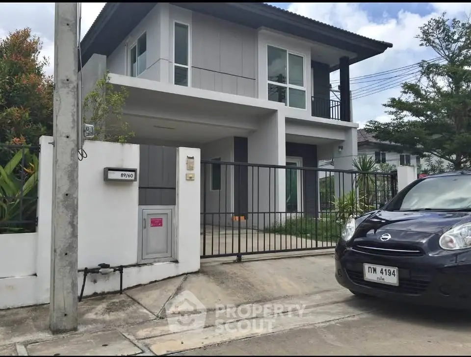 Modern two-story house with gated entrance and driveway