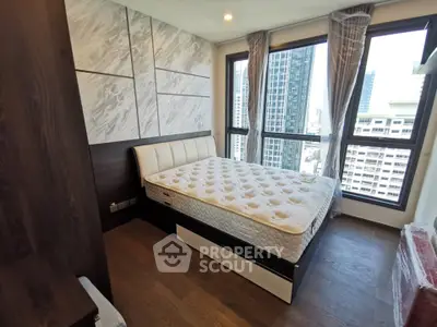 Modern bedroom with large windows and city view in high-rise apartment