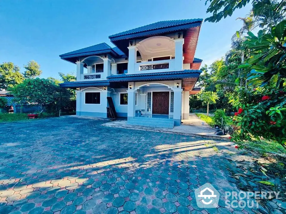 Stunning two-story house with spacious driveway and lush greenery, perfect for family living.