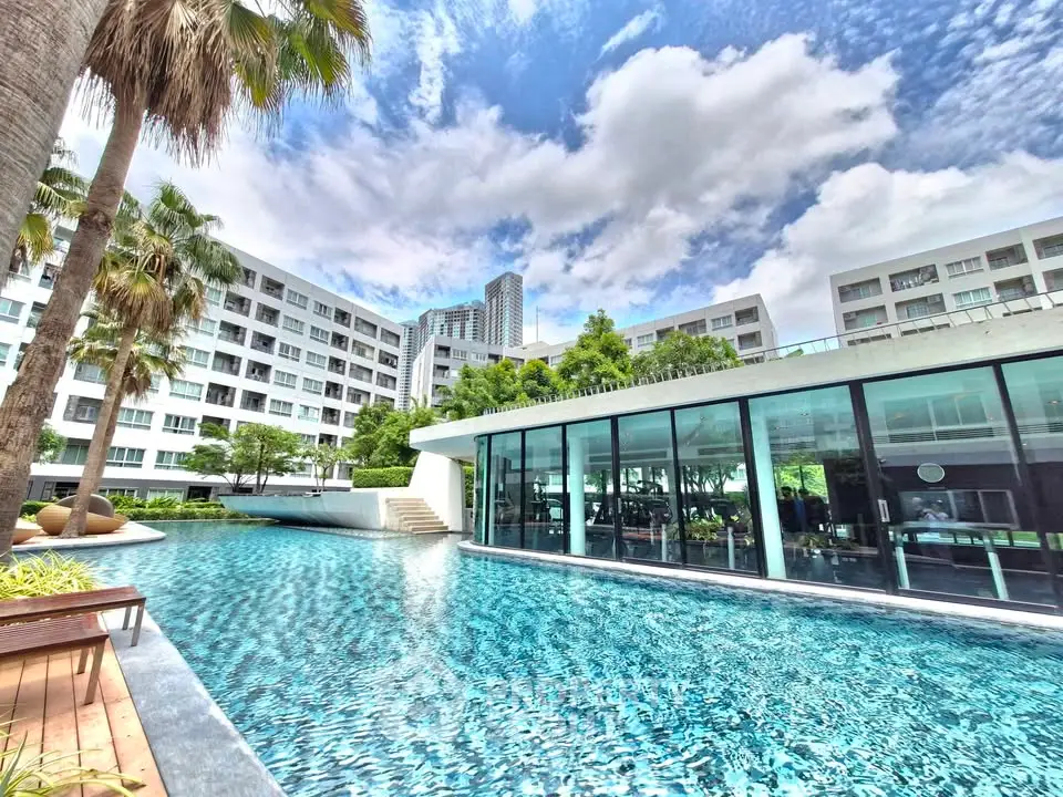 Luxurious residential complex with stunning pool and modern architecture under a vibrant sky.