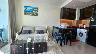 Chic living room with modern kitchen and washing machine, featuring cozy seating and stylish decor.