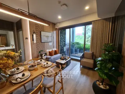 Modern living room with elegant dining area and balcony view, featuring stylish decor and natural light.