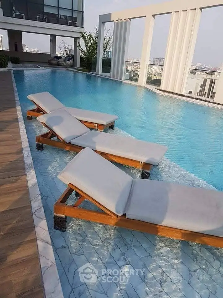 Luxurious rooftop pool with stylish sun loungers and stunning city views, perfect for relaxation and leisure.