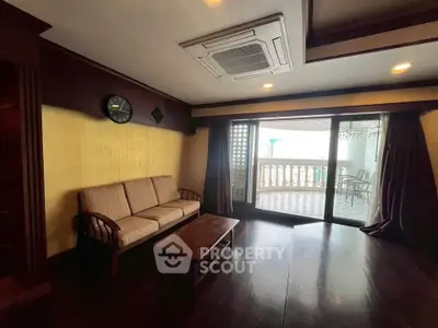 Spacious living room with cozy sofa and large balcony access