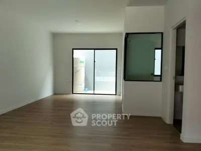 Spacious empty room with wooden flooring and large window