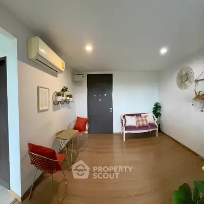 Charming living room with modern decor and cozy seating area, featuring stylish wall art and warm lighting.
