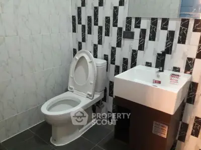 Modern bathroom with stylish black and white tiles and sleek fixtures.