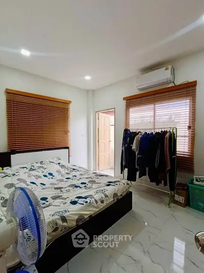 Cozy bedroom with modern decor, featuring a comfortable bed, air conditioning, and ample natural light.