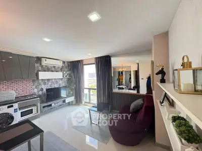 Modern living room with sleek kitchen, cozy seating, and large window offering natural light.