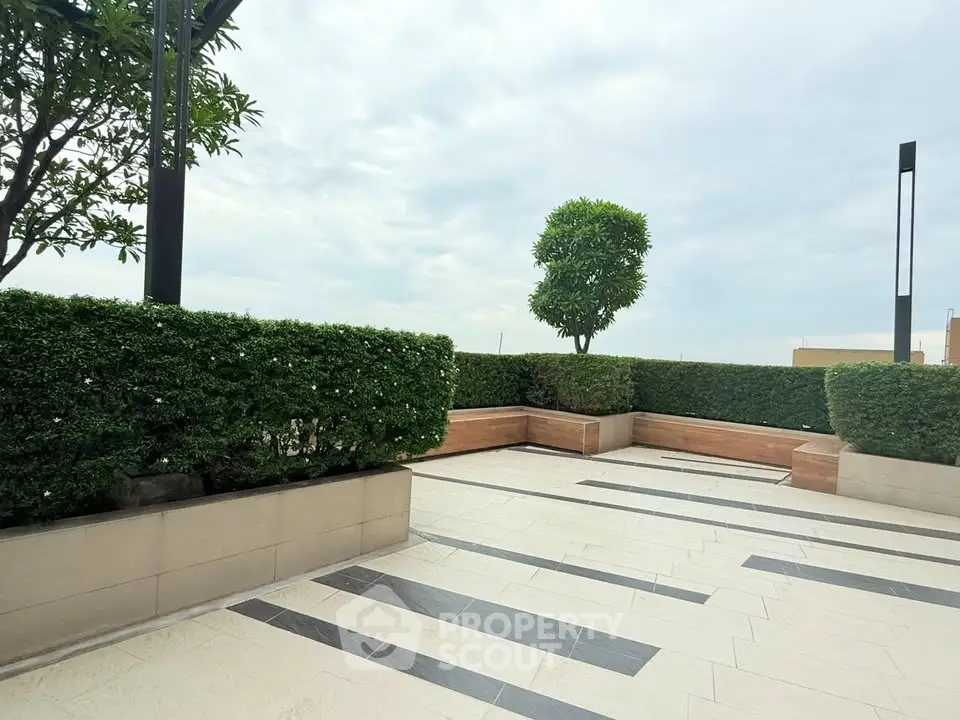 Spacious rooftop terrace with modern design and lush greenery, perfect for relaxation and entertainment.