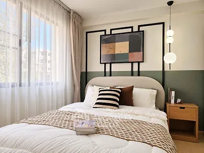 Cozy bedroom with modern decor and large window offering natural light.