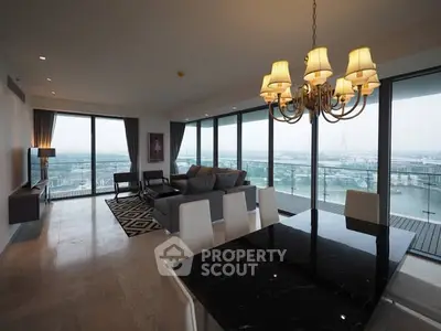Luxurious open-plan living room with stunning city view and elegant chandelier.