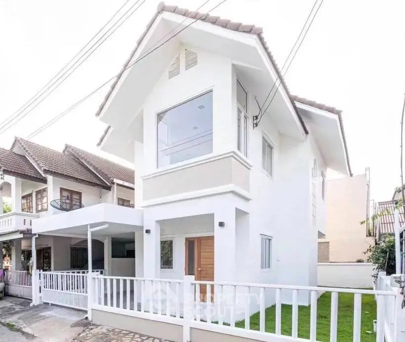 Charming two-story white house with modern design and fenced yard in a serene neighborhood.