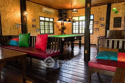 Charming rustic interior with pool table and cozy seating, perfect for entertainment and relaxation.
