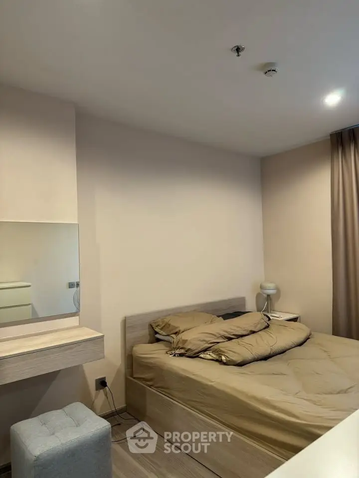 Cozy bedroom with modern decor and neutral tones, featuring a comfortable bed and stylish furnishings.
