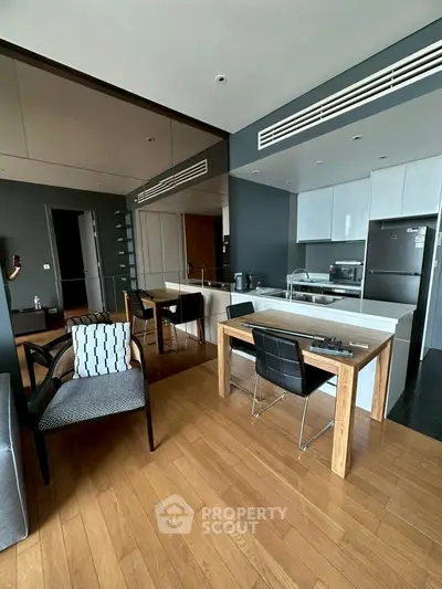 Modern open-plan kitchen and dining area with sleek design and wooden flooring.