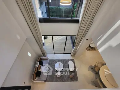Stunning modern living room with high ceilings and large windows, offering a bright and airy atmosphere.