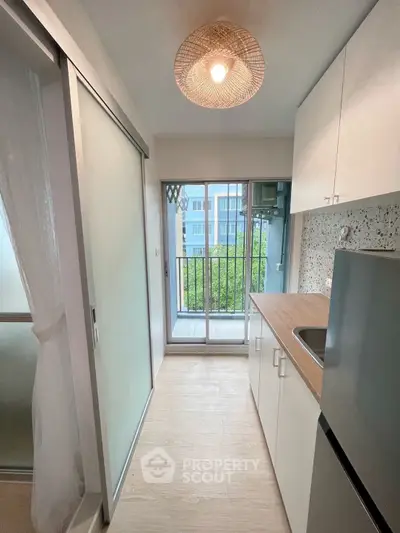 Modern compact kitchen with balcony view and sleek design