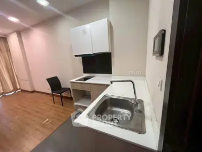 Modern kitchen with sleek cabinetry and sink in open layout apartment
