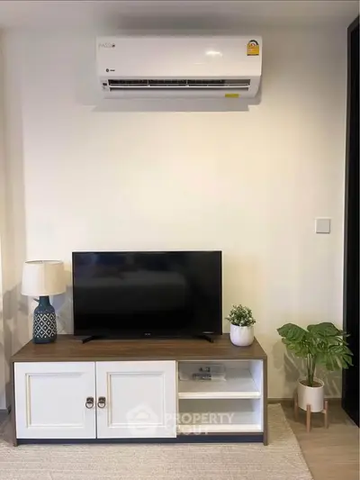 Modern living room with air conditioner, TV, and stylish decor
