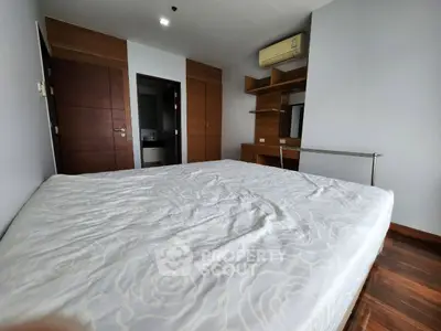 Spacious bedroom with wooden accents and built-in air conditioning unit.