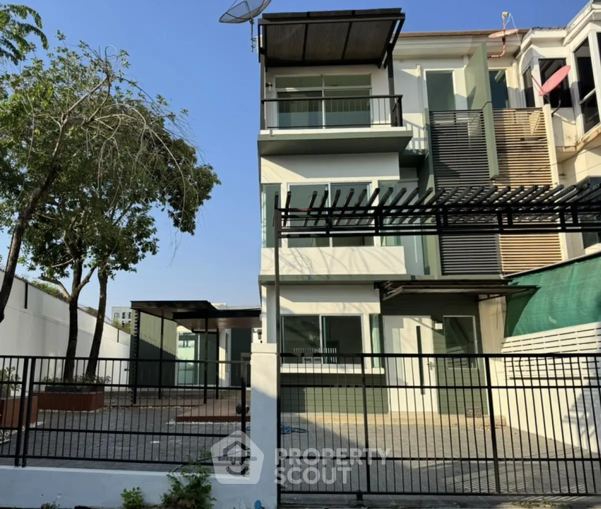 Modern three-story townhouse with spacious driveway and sleek exterior design.