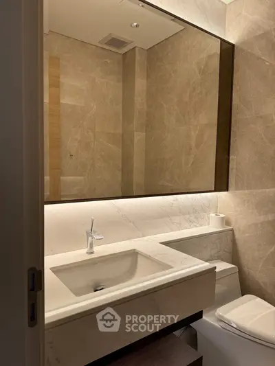 Luxurious bathroom with marble finishes and modern fixtures in upscale property.