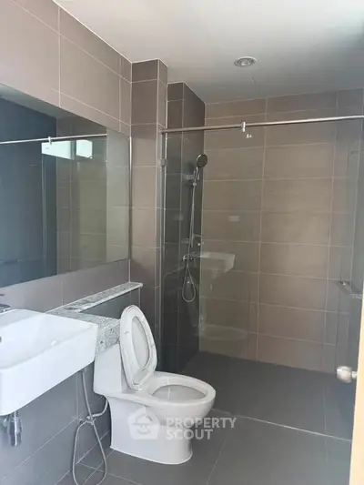 Modern bathroom with sleek design, featuring a glass shower enclosure and contemporary fixtures.