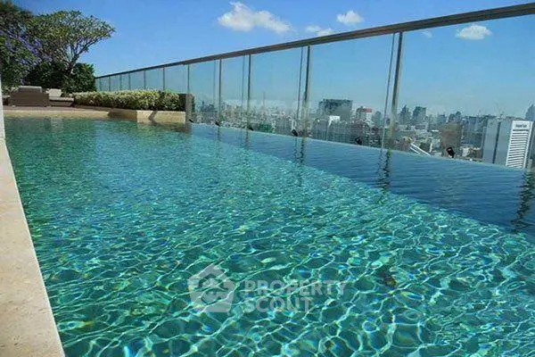 Luxurious rooftop infinity pool with stunning city skyline view, perfect for relaxation and leisure.