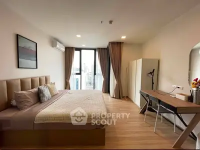 Spacious modern bedroom with city view, elegant decor, and natural light.