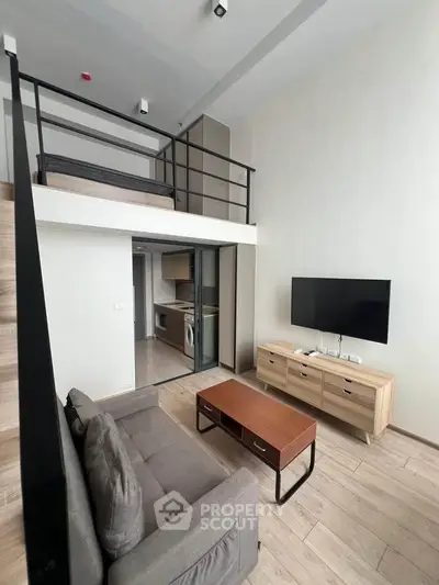 Modern loft-style living room with mezzanine, sleek furniture, and integrated kitchen appliances.