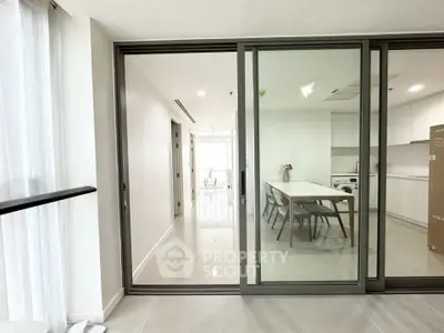 Modern open-plan kitchen and dining area with sleek sliding glass doors