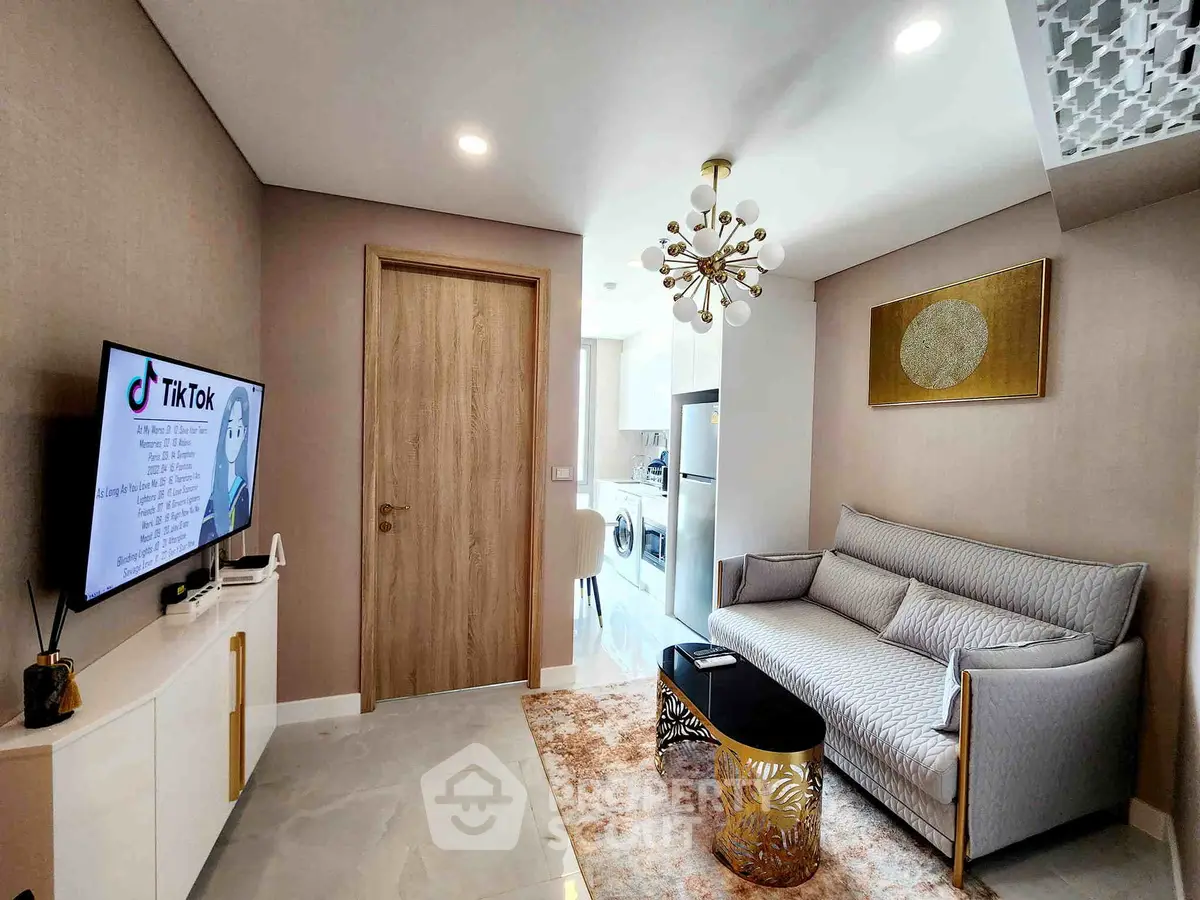 Modern living room with stylish decor and open kitchen layout, featuring a cozy sofa and elegant lighting.